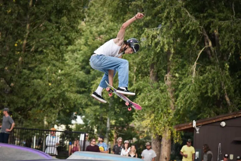 Skateboarder mid-air above a crowd at Skate4Nate